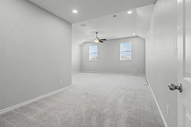 an empty room with a ceiling fan and window