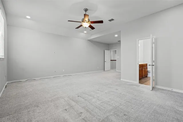 a view of an empty room with a ceiling fan