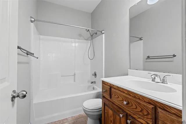 a bathroom with a granite countertop sink a toilet and shower