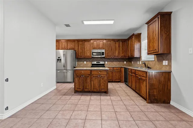 a kitchen with stainless steel appliances granite countertop a stove top oven a sink a counter top space and cabinets