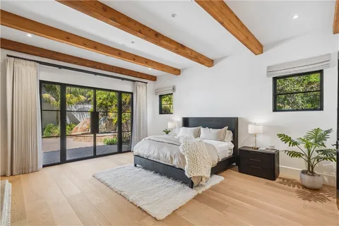 a living room with furniture a flat screen tv and a floor to ceiling window