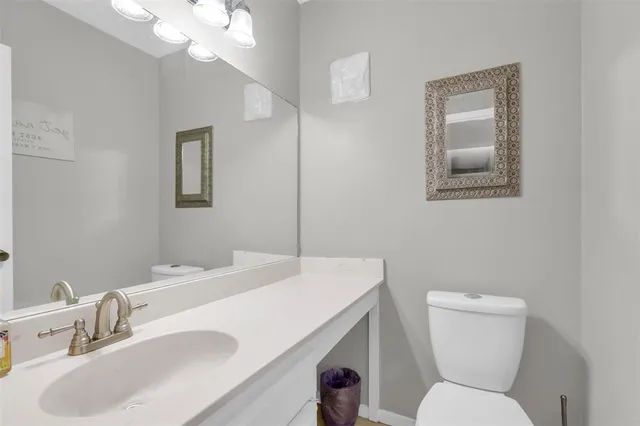 a bathroom with a sink a toilet a mirror and vanity
