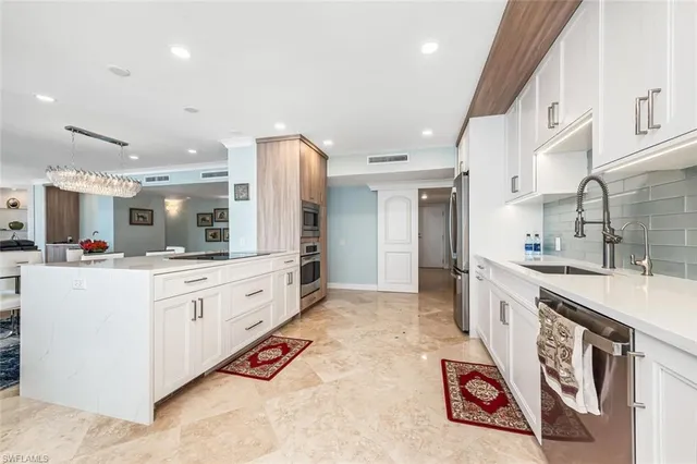 a large white kitchen with stainless steel appliances lots of counter top space