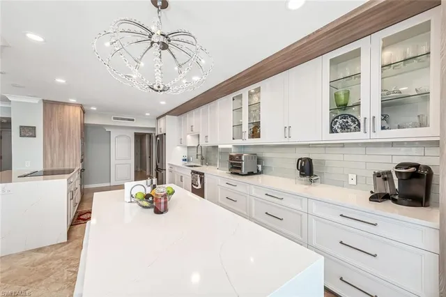 a kitchen with a white cabinets and chandelier