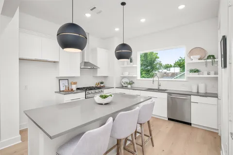 a kitchen with stainless steel appliances kitchen island a table and chairs in it