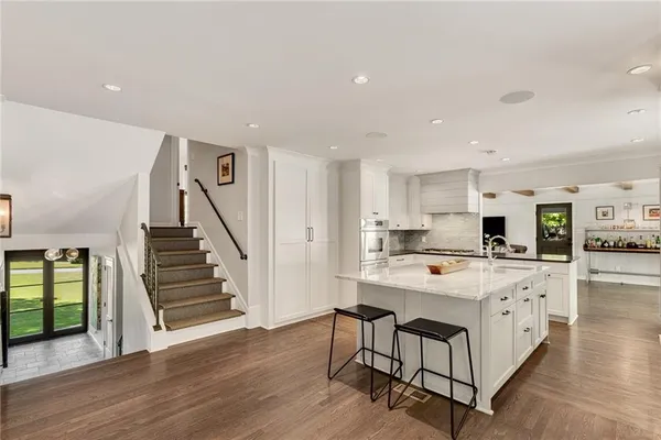 a kitchen with granite countertop white cabinets and white appliances