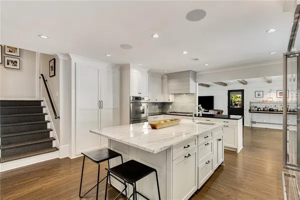 a kitchen with kitchen island granite countertop a sink a counter space appliances and cabinets