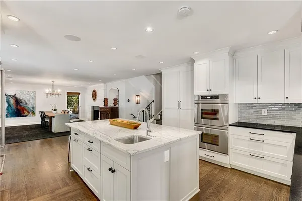 a dining room with furniture a chandelier and kitchen view