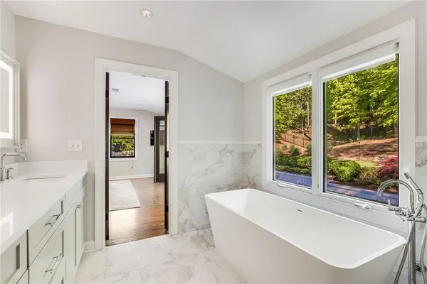 a bathroom with a granite countertop toilet sink and mirror