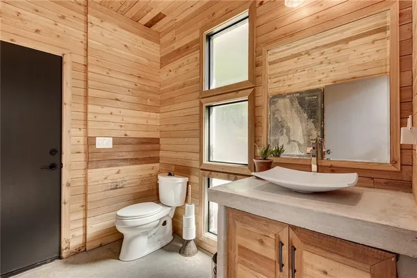 a spacious bathroom with a granite countertop sink toilet a mirror and shower