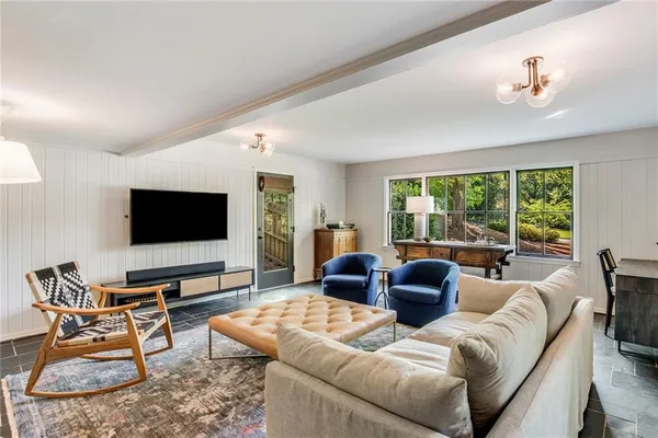a white bed sitting in a bedroom next to a window