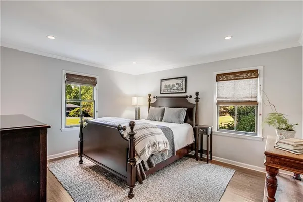 a large white kitchen with wooden floor and a sink