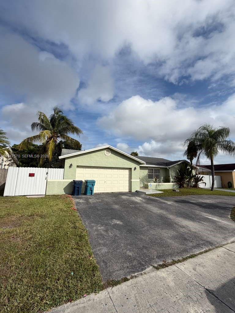 12241 Southwest 268th Street, Unit 1 Homestead, FL 33032 - Photo 2 of 25 a view of a house with a big yard and large trees