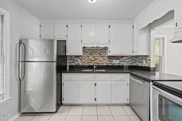 a kitchen with granite countertop cabinets stainless steel appliances and a sink