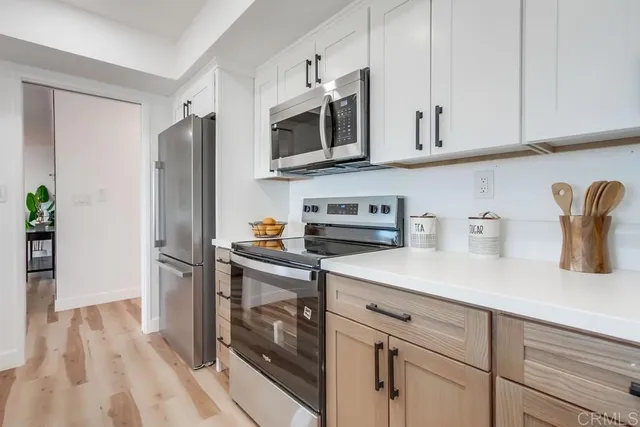 a kitchen with stainless steel appliances a table chairs refrigerator and microwave