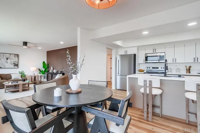 a kitchen with stainless steel appliances a dining table chairs and granite counter tops