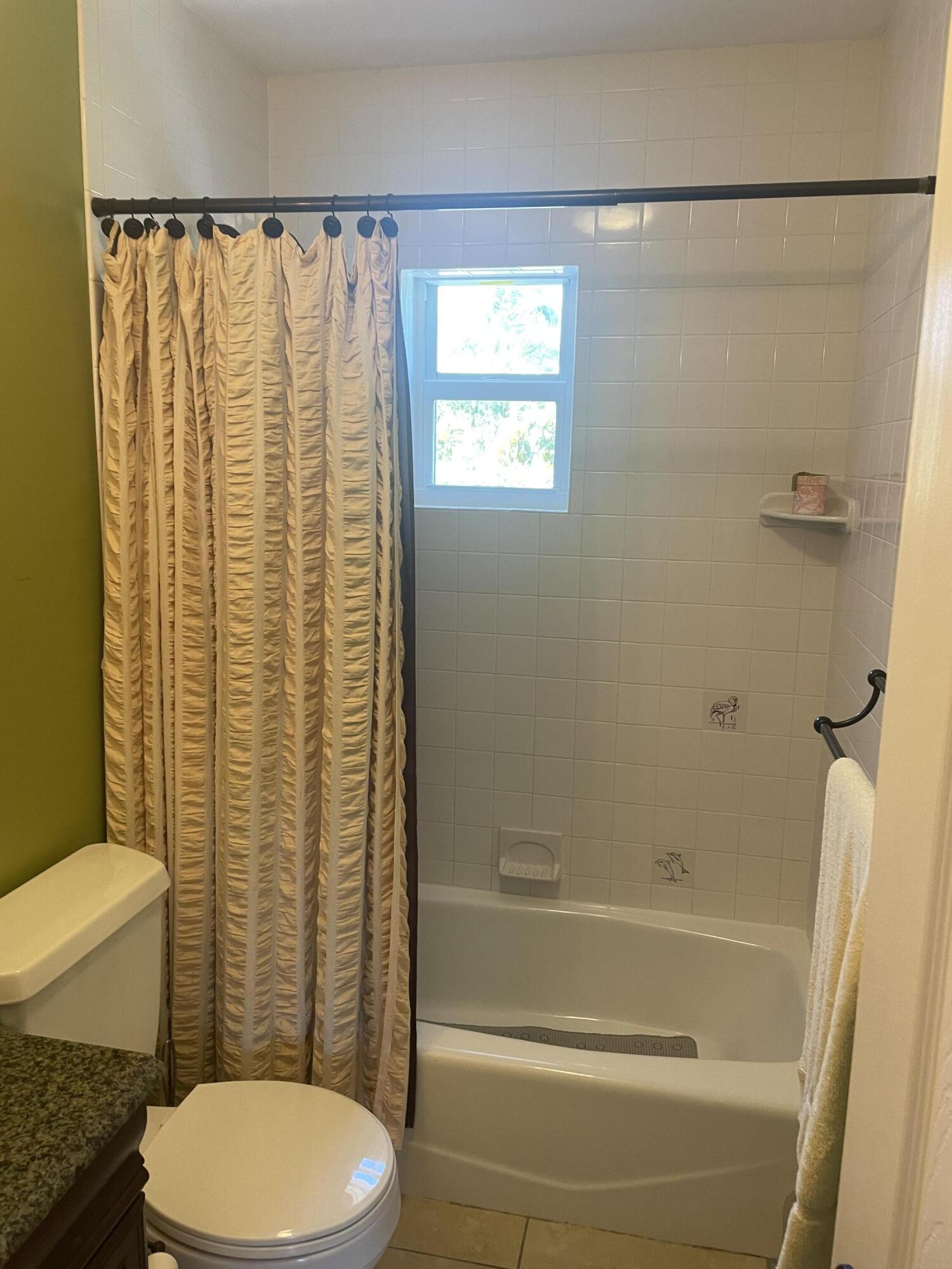 Undisclosed Address Big Pine Key, FL 33043 - Photo 10 of 28 a bathroom with a toilet and a shower curtain