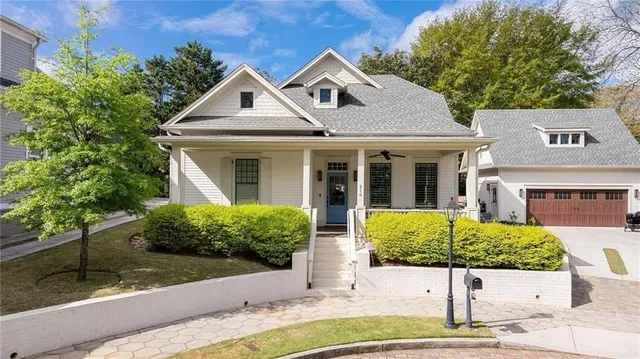 a front view of a house with a yard and potted plants