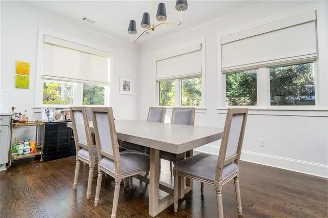 a view of a dining room with furniture a chandelier and wooden floor