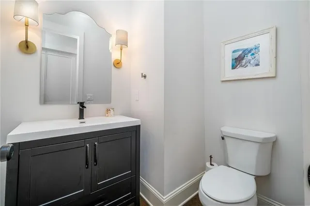 a bathroom with a toilet sink and mirror