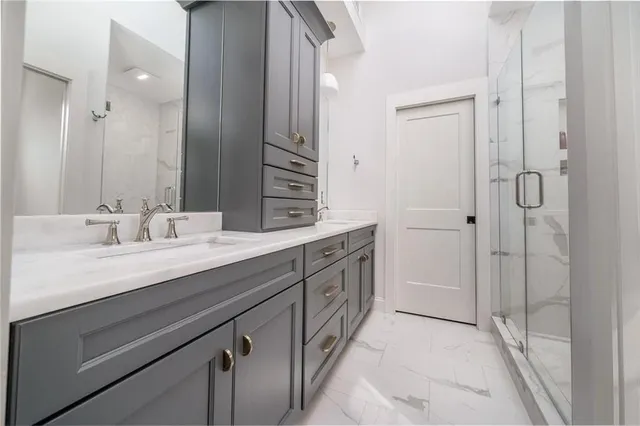 a spacious bathroom with a double vanity sink a mirror and a shower