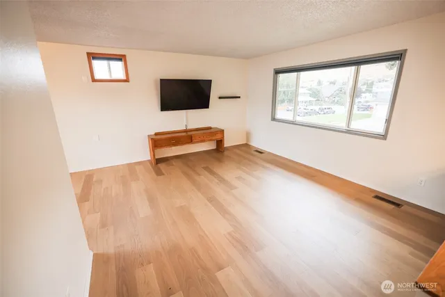 a view of a livingroom with wooden floor and a flat screen tv