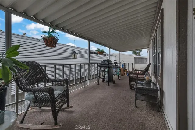 a roof deck with table and chairs and potted plants