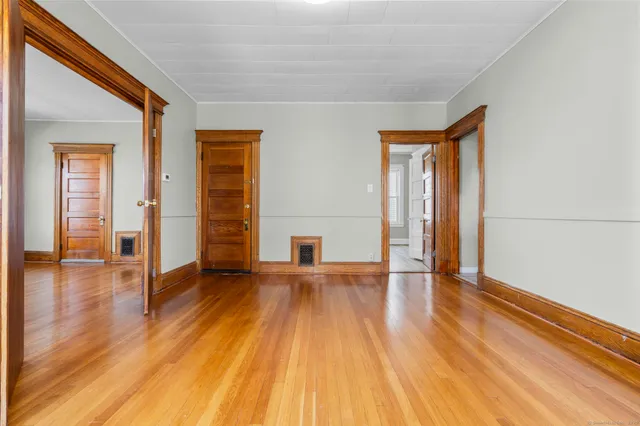 a view of empty room with wooden floor and fan