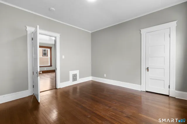 a view of empty room with wooden floor