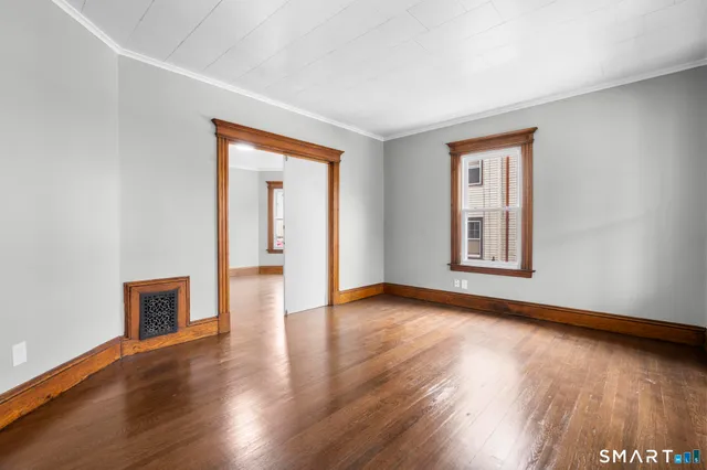 a view of an empty room with wooden floor