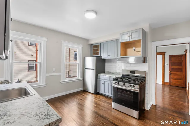 a kitchen with stainless steel appliances granite countertop a stove a sink and a refrigerator