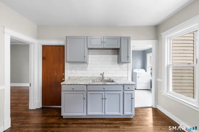 a kitchen with stainless steel appliances granite countertop a sink and wooden floors