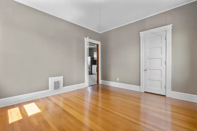 an empty room with wooden floor and closet