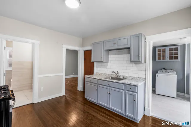 a kitchen with a sink and wooden floor