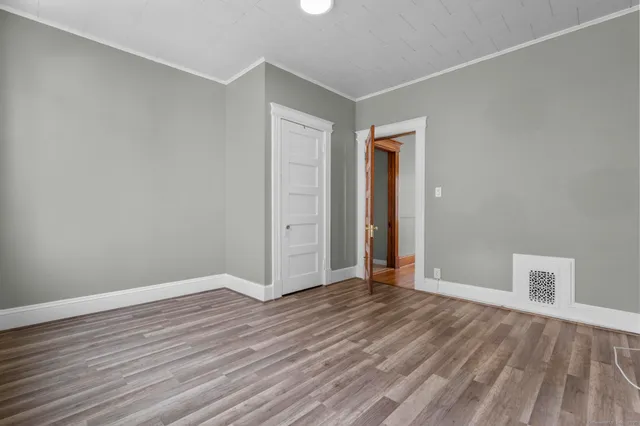 a view of an empty room with wooden floor