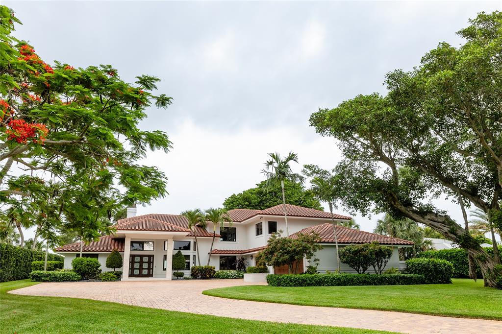 a front view of a house with a yard and potted plants