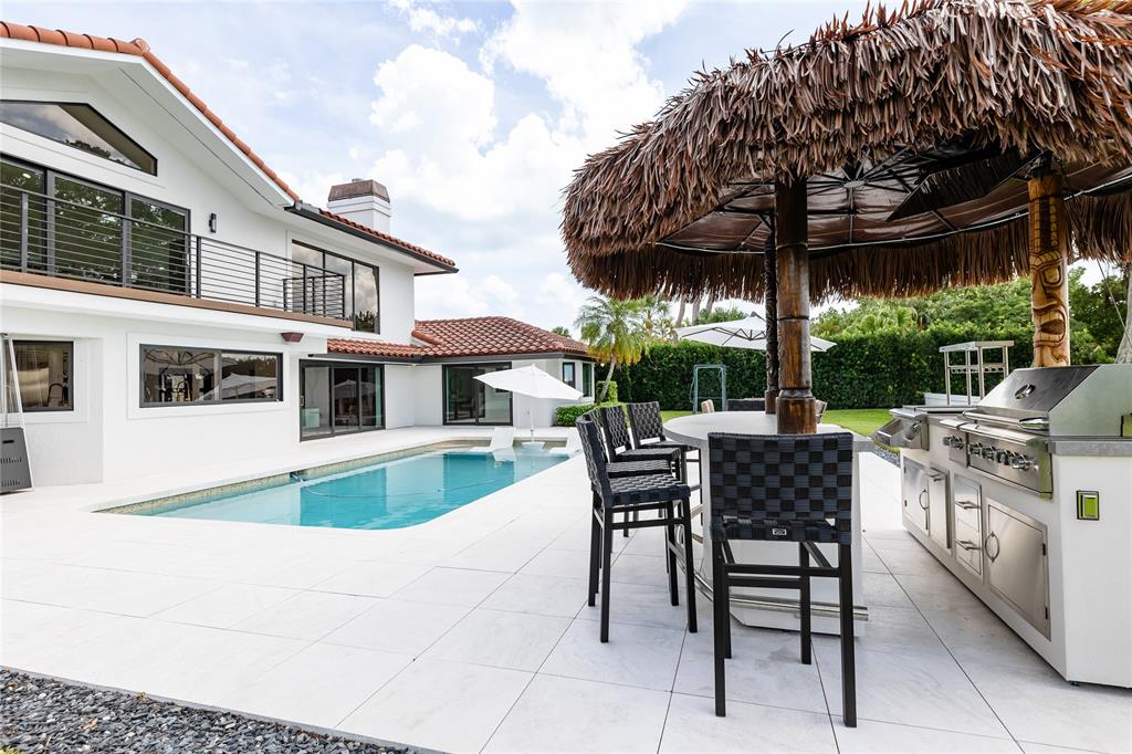 9 North River Road Stuart, FL 34996 - Photo 16 of 75 a view of a patio with a table and chairs under an umbrella
