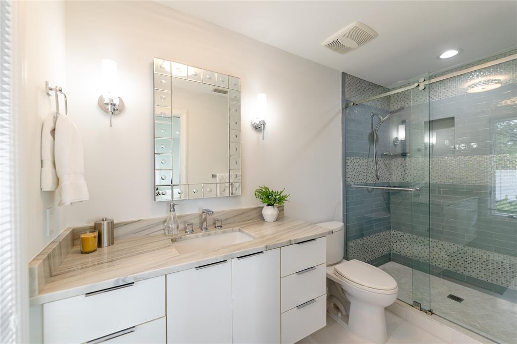 9 North River Road Stuart, FL 34996 - Photo 55 of 75 a bathroom with a granite countertop sink a toilet a mirror and shower