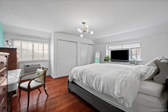 a spacious bedroom with a bed and a chandelier