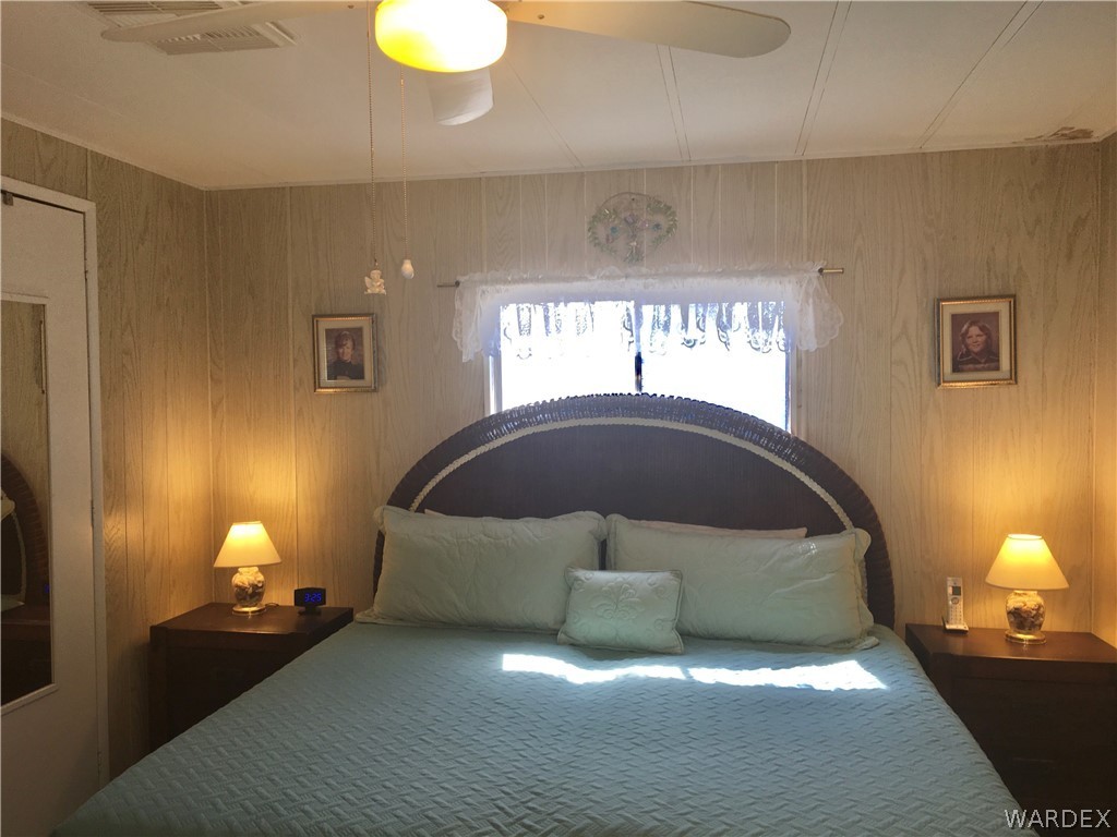 1745 Talc Road Bullhead City, AZ 86442 - Photo 12 of 31 a spacious bedroom with a bed and a lamp