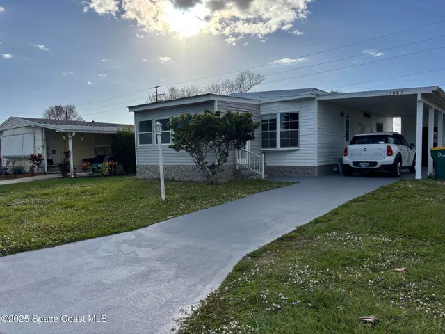 a view of a house with a yard and sitting area