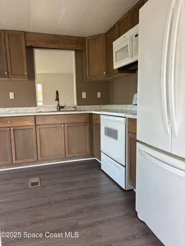 a kitchen with granite countertop white cabinets and white appliances