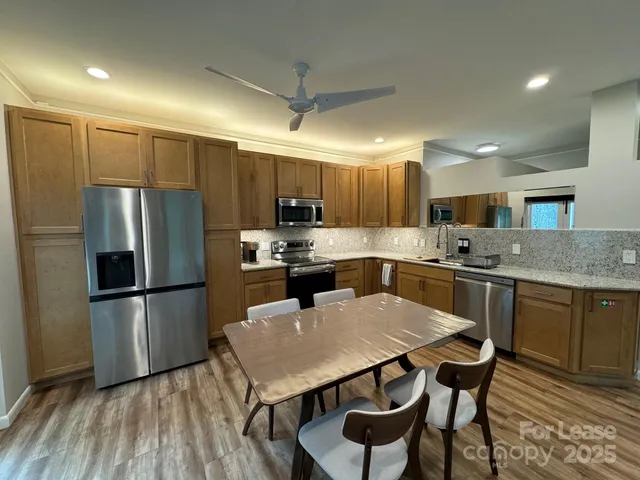 a kitchen with kitchen island a refrigerator a stove a sink and a oven