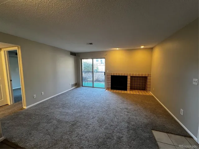 a view of empty room with a fireplace
