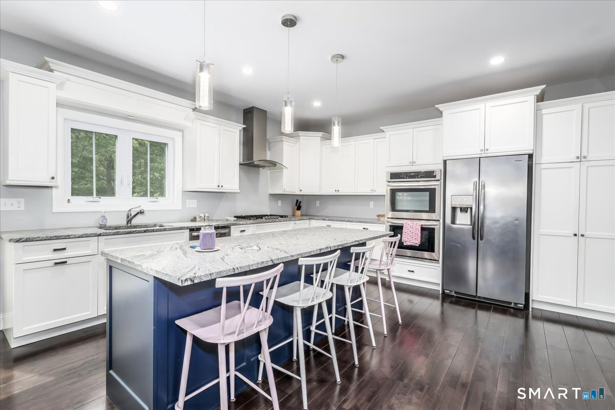 127 Putnam Park Road Bethel, CT 06801 - Photo 4 of 35 a kitchen with stainless steel appliances granite countertop a table chairs sink refrigerator and microwave