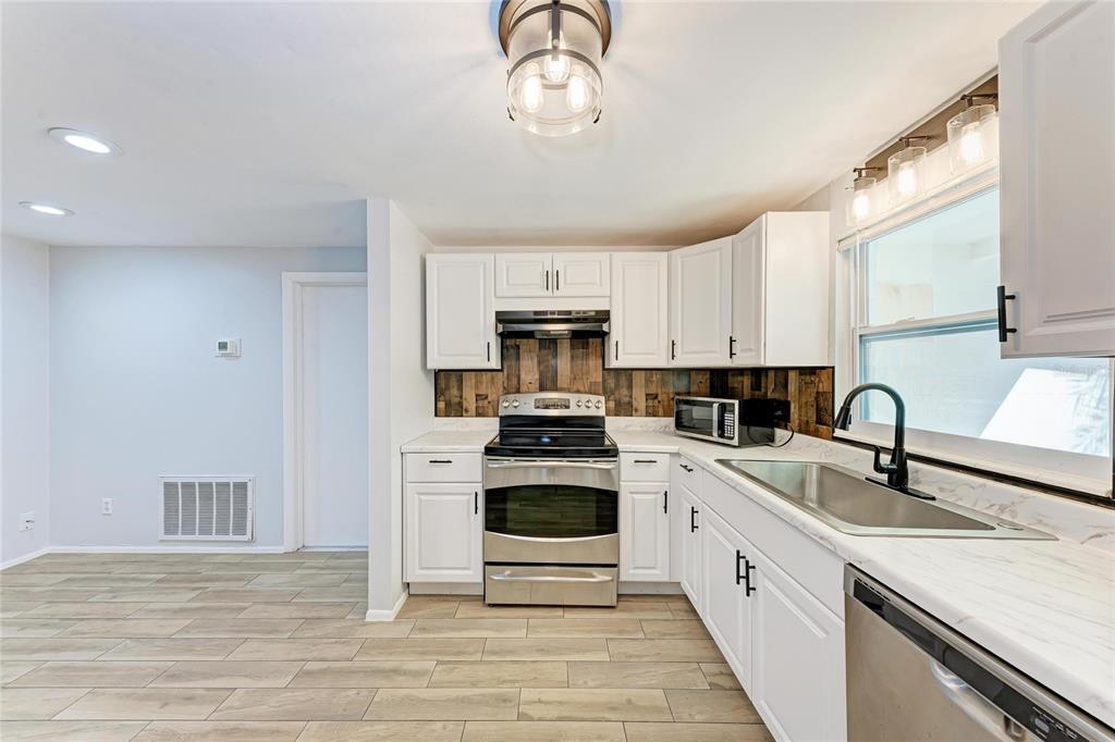 4010 South Lockwood Ridge Road Sarasota, FL 34231 - Photo 11 of 48 a kitchen with white cabinets and appliances