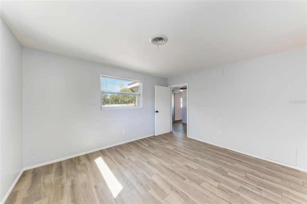 4010 South Lockwood Ridge Road Sarasota, FL 34231 - Photo 18 of 48 a view of an empty room with wooden floor and a window