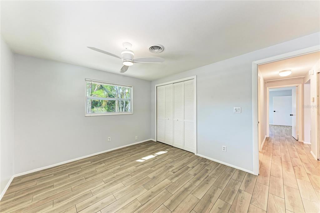 4010 South Lockwood Ridge Road Sarasota, FL 34231 - Photo 21 of 48 an empty room with wooden floor and windows
