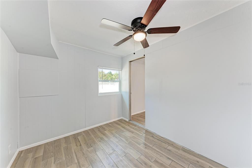 4010 South Lockwood Ridge Road Sarasota, FL 34231 - Photo 24 of 48 an empty room with wooden floor fan and windows