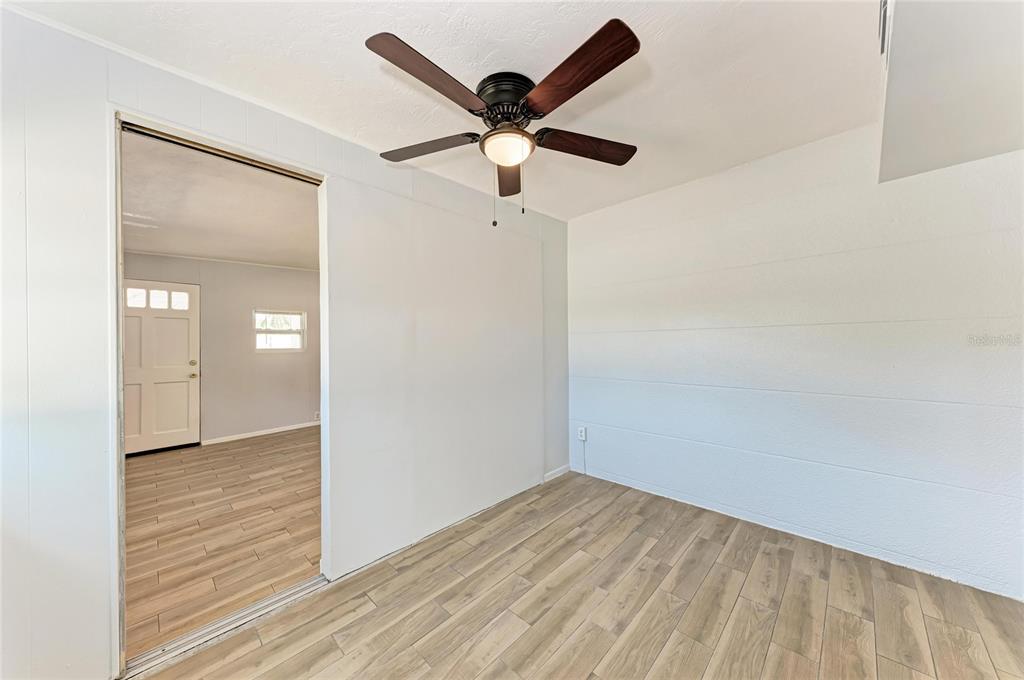 4010 South Lockwood Ridge Road Sarasota, FL 34231 - Photo 25 of 48 an empty room with wooden floor and ceiling fan